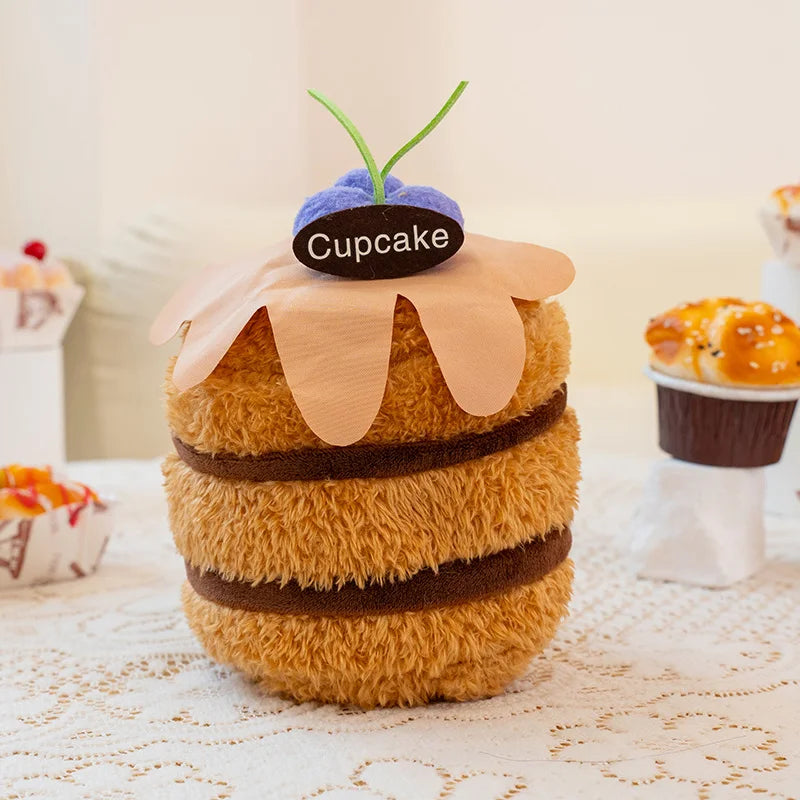 Plush toy resembling a cupcake with a cherry on top on a lace tablecloth.