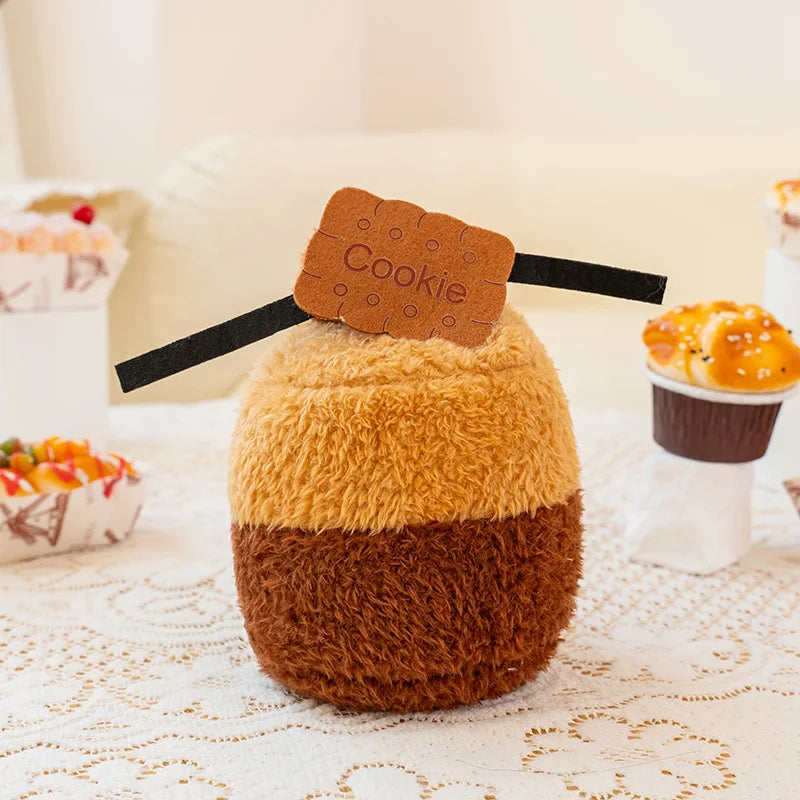Fluffy brown and orange plush toy with a 'Cookie' label on a lace tablecloth.