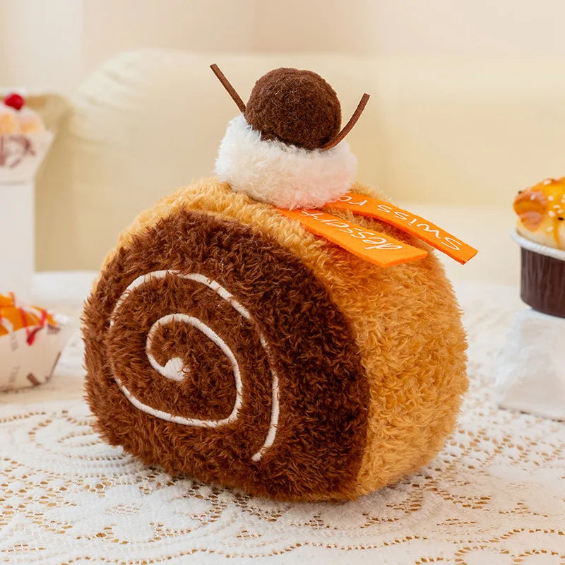 Plush toy resembling a roll cake with a small ant on top, placed on a lace tablecloth.