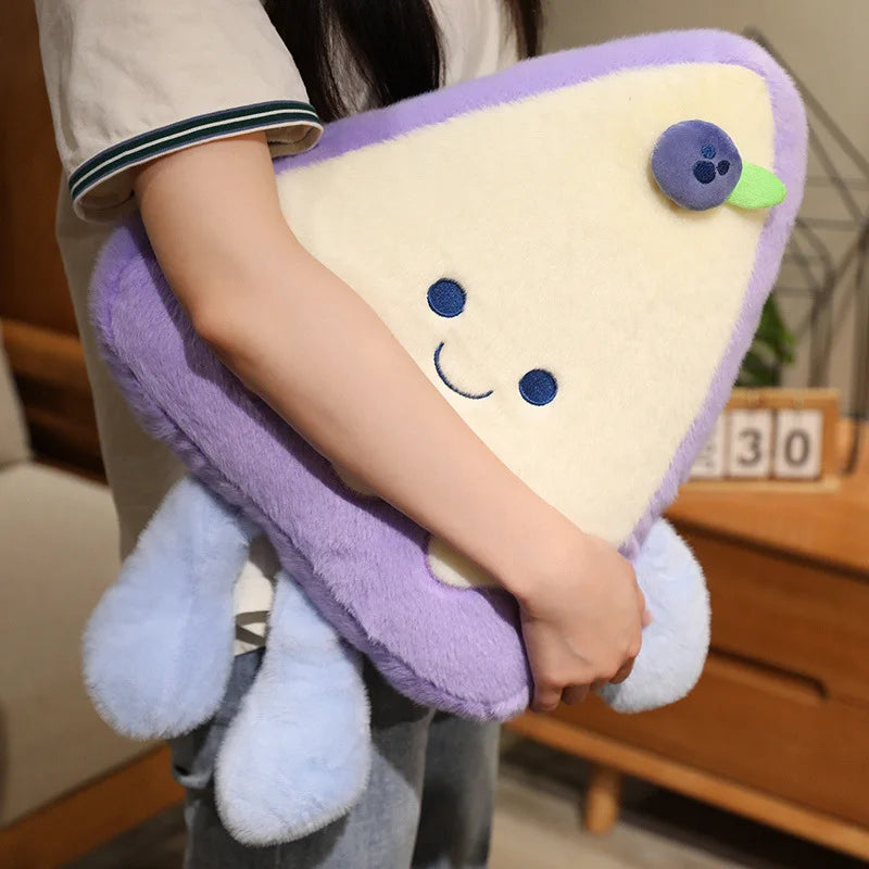 Person holding a plush toy shaped like a slice of cake with a face.