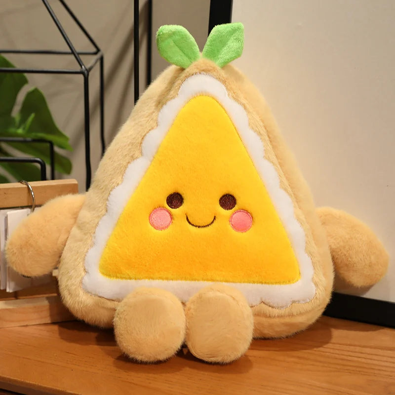 Plush toy shaped like a cake slice with a yellow triangle body on a wooden surface.
