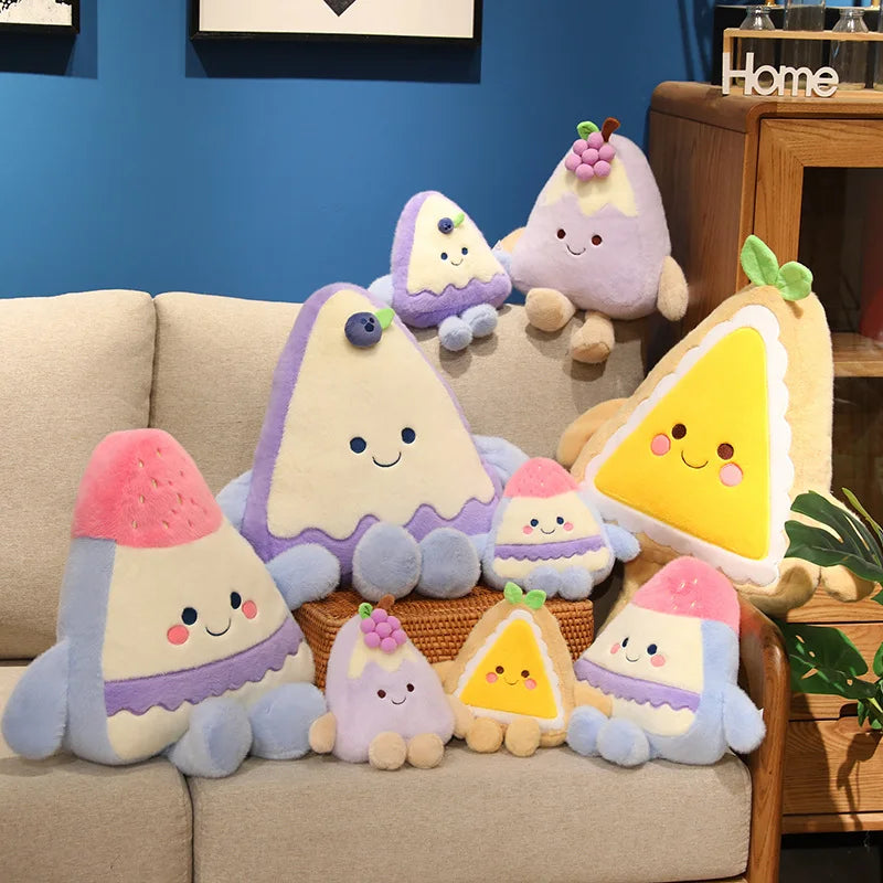 Colorful plush toys shaped like cakes and pies on a couch with a blue wall in the background.