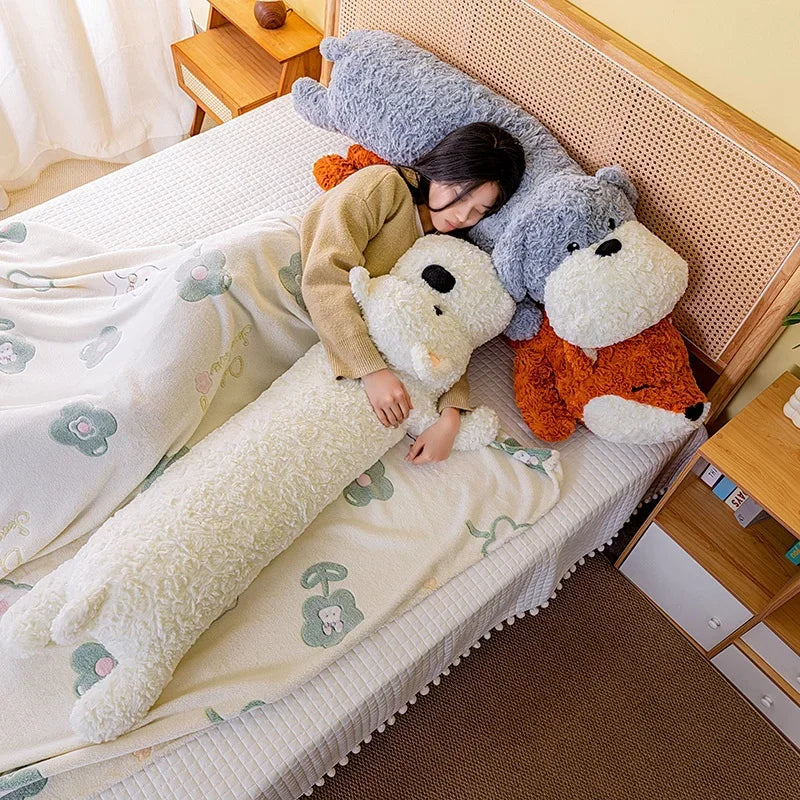 Person lying on a bed with large kawaii plushie body pillow toys shaped like fox and dogs