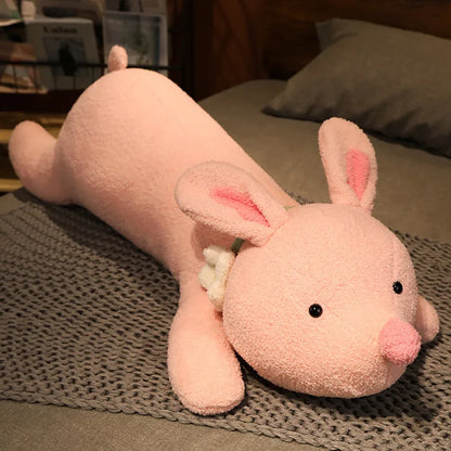 Pink plush toy resembling a rabbit on a textured surface