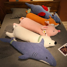 Plush toys including a shark, pig, and others on a bed