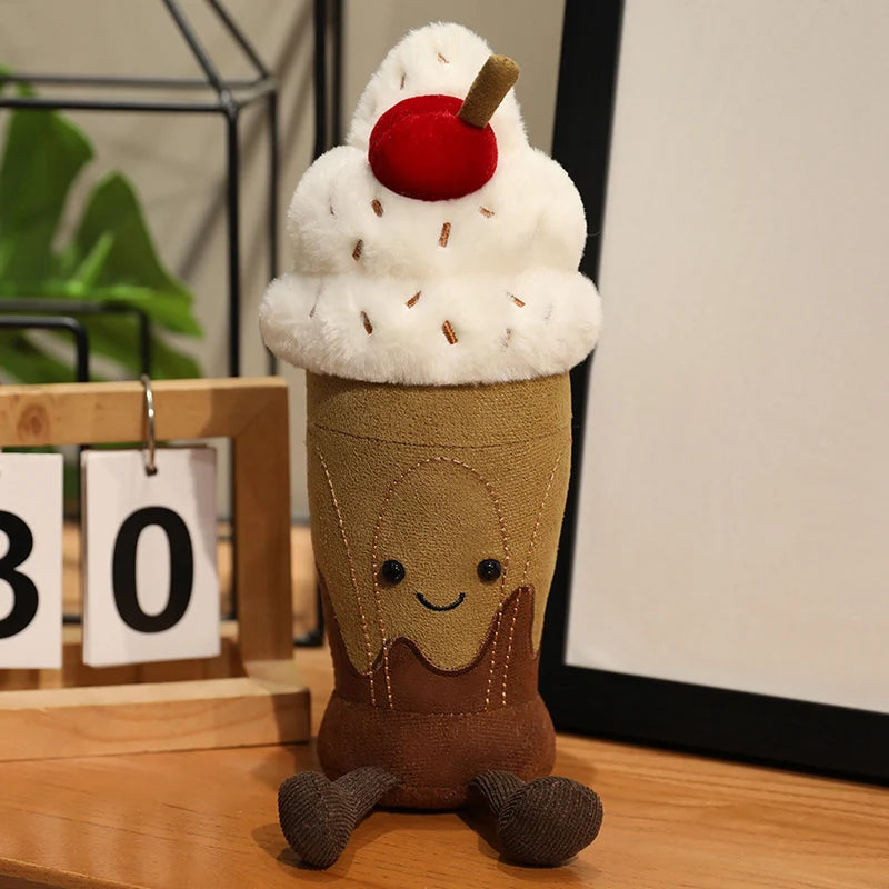Plush toy resembling a milkshake with a cherry on top on a wooden surface.
