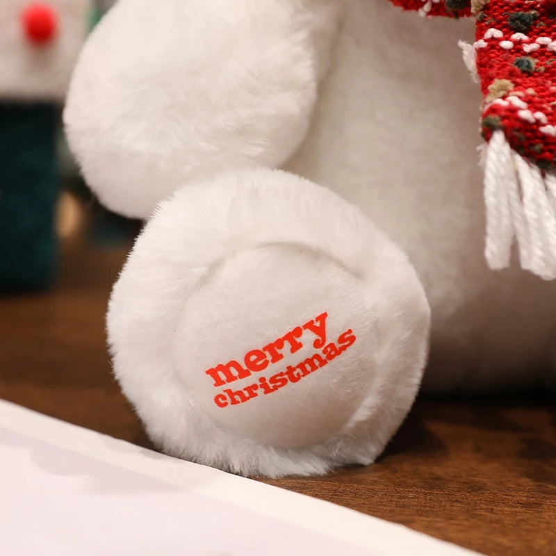 White plush toy with 'merry christmas' text on a wooden surface