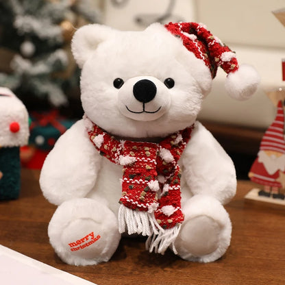 White teddy bear with a red scarf and hat on a wooden surface with Christmas decorations in the background.