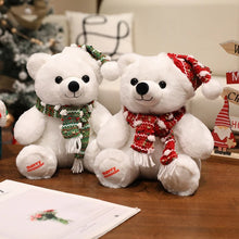 Two white teddy bears with Christmas scarves and hats on a wooden surface.