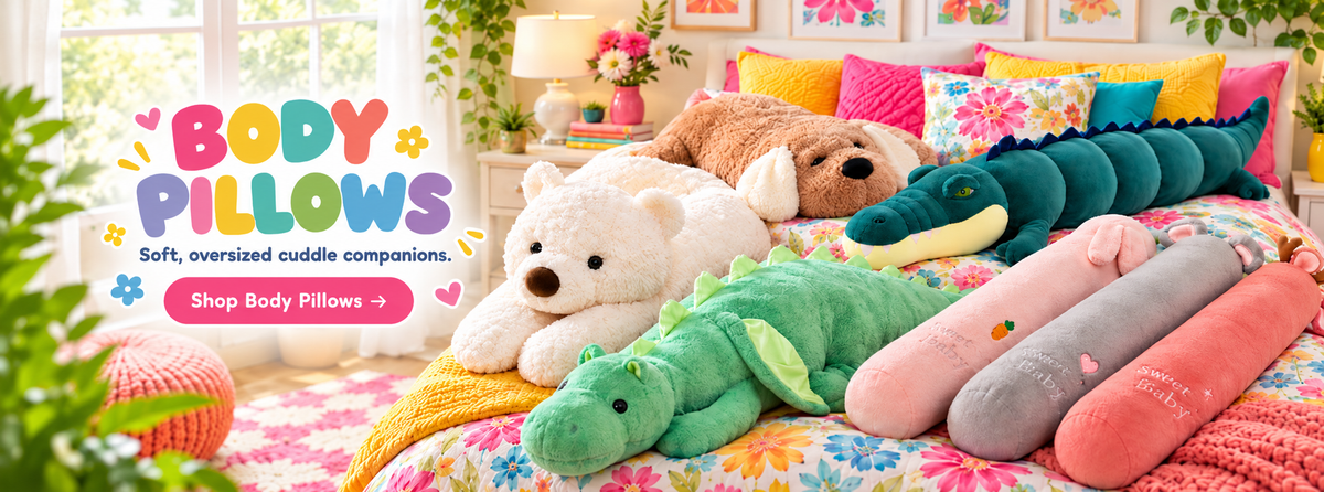 Dandelion Vine body pillow collection featuring the Crocodile Long Plushie Body Pillow, Premium Snuggle Dog Plushie Pillow, Bearly Awake Teddy Bear Body Pillow, Mythic Hugs Giant Dragon Plushie and colorful Sleepy Critters long body pillows arranged on a bright floral bed.