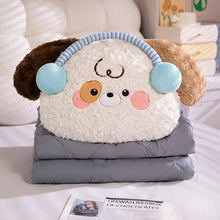 Plush dog-shaped blanket with cartoon face on a bed