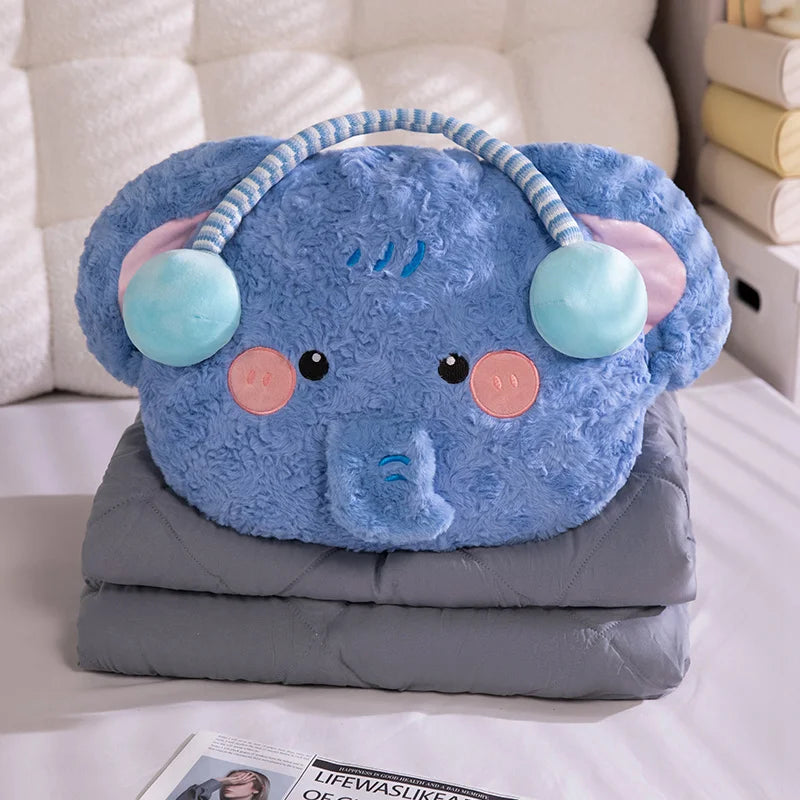 Blue plush elephant toy with pink cheeks and green ears on a gray blanket