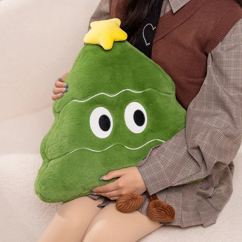 Person holding a green plush toy shaped like a Christmas tree on a beige couch.