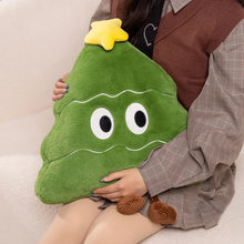 Person holding a green plush toy shaped like a Christmas tree on a beige couch.