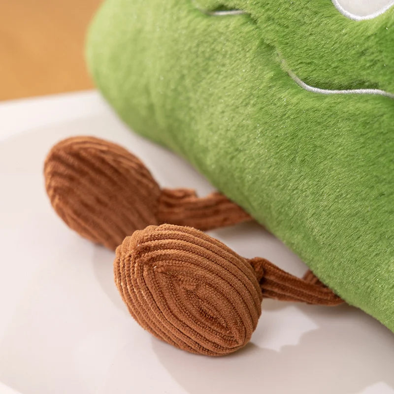 Green plush toy with brown accents on a white surface