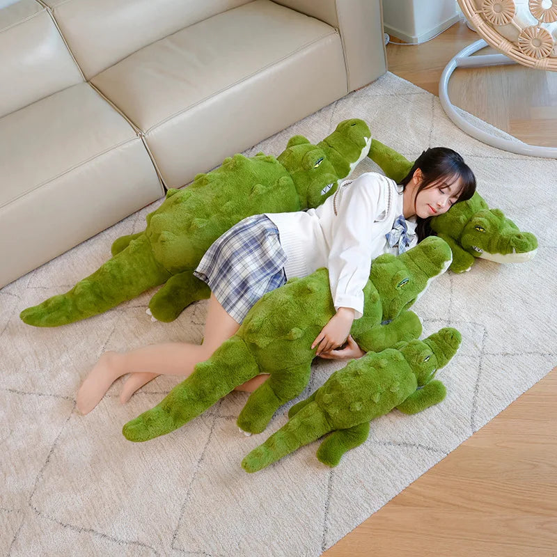 Woman lying on a floor with multiple green plush alligator body pillows