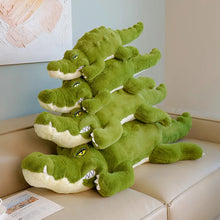 Stack of green plush alligators on a beige couch