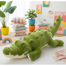 Green plush crocodile toy on a table with colorful pillows and plants in the background