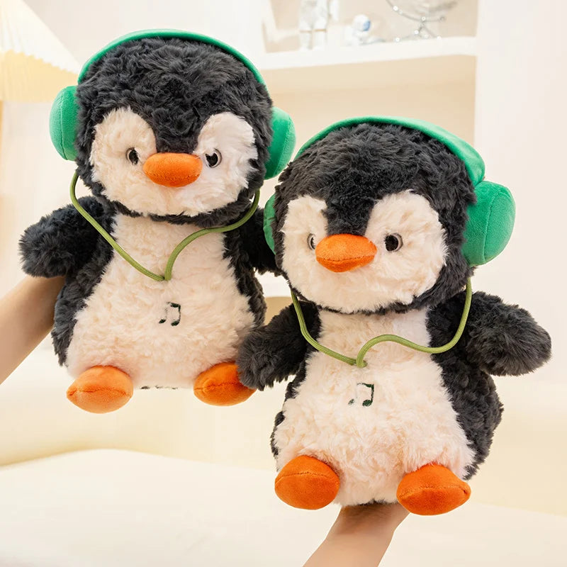 Two plush penguins with green headphones on a light background