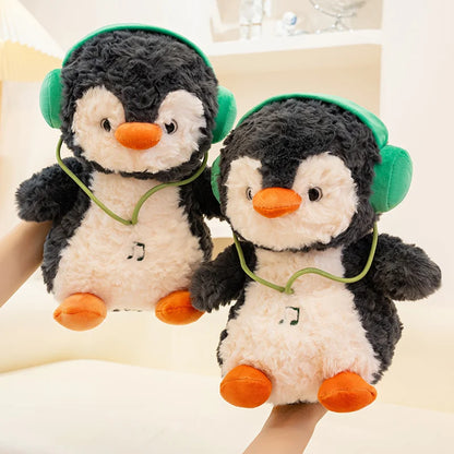 Two plush penguins with green headphones on a light background