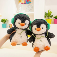 Two plush penguins with headphones on a light-colored surface.