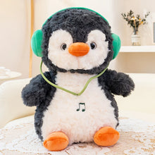 Plush toy penguin with headphones on a light surface