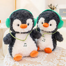 Two plush penguins with headphones on a lace tablecloth.