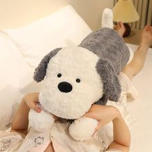 Person holding a large plush dog toy in a bedroom setting