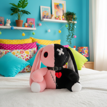 Plush toy with pink and black design on a bed with colorful pillows and decor.