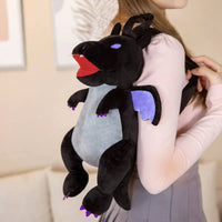 Black dragon plushie backpack on shoulder of a woman