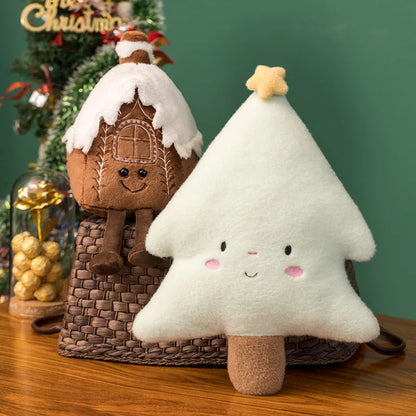 Plush toy gingerbread house and tree on a wooden surface with a festive background