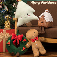 Christmas-themed plush toys including a gingerbread man, wreath, and tree on a brown surface with 'Merry Christmas' text.