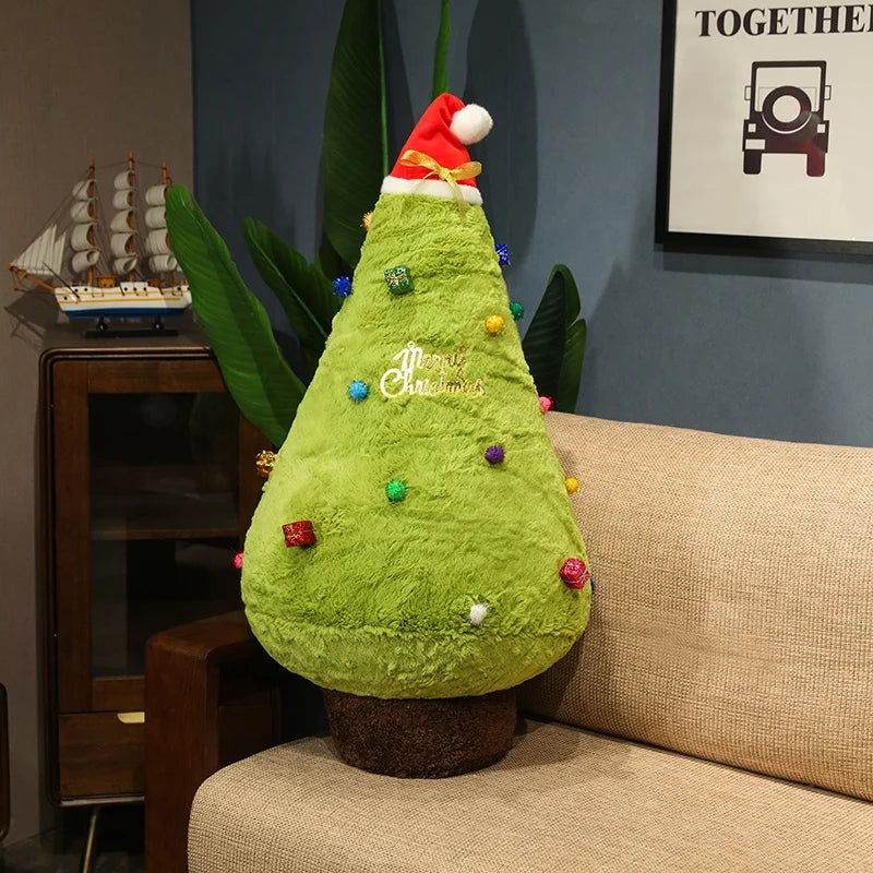 Green Christmas tree-shaped pillow with colorful decorations on a couch