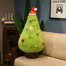 Green Christmas tree-shaped pillow with colorful decorations on a couch
