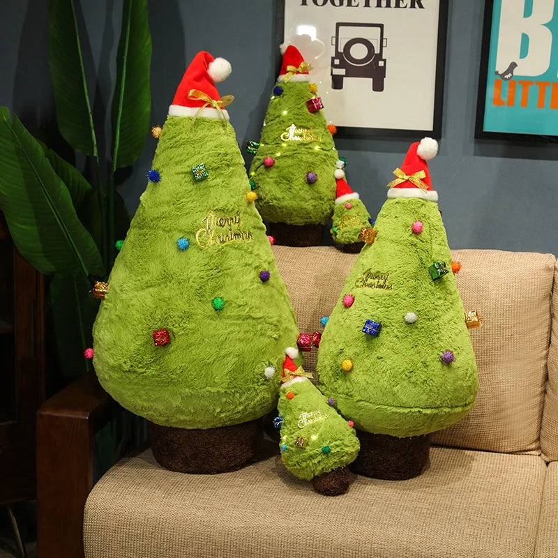 Set of green Christmas tree-shaped plushie pillows with decorative elements on a couch.