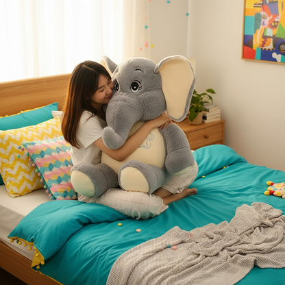 Person hugging a large plush elephant toy on a bed with colorful bedding and pillows.
