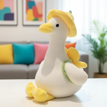 Plush toy duck with a yellow hat on a table in a living room setting