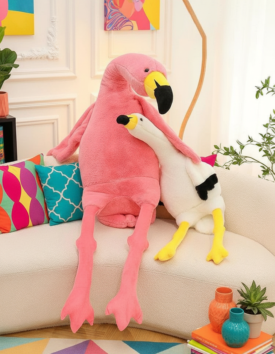 Two plush flamingo toys on a couch in a living room setting.