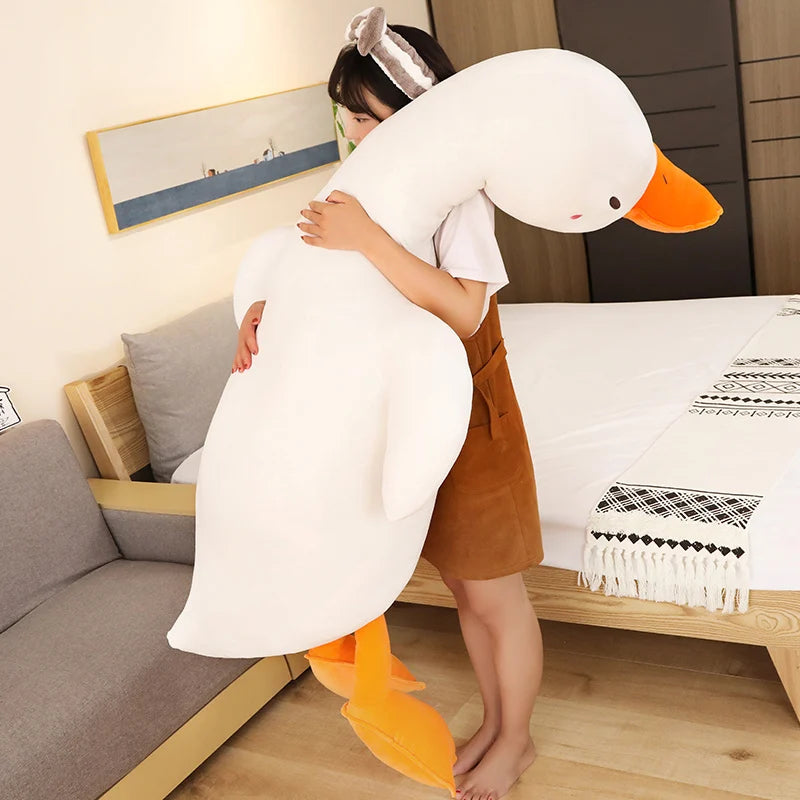 Person holding a large nflatable duck plushie body pillow in a living room.