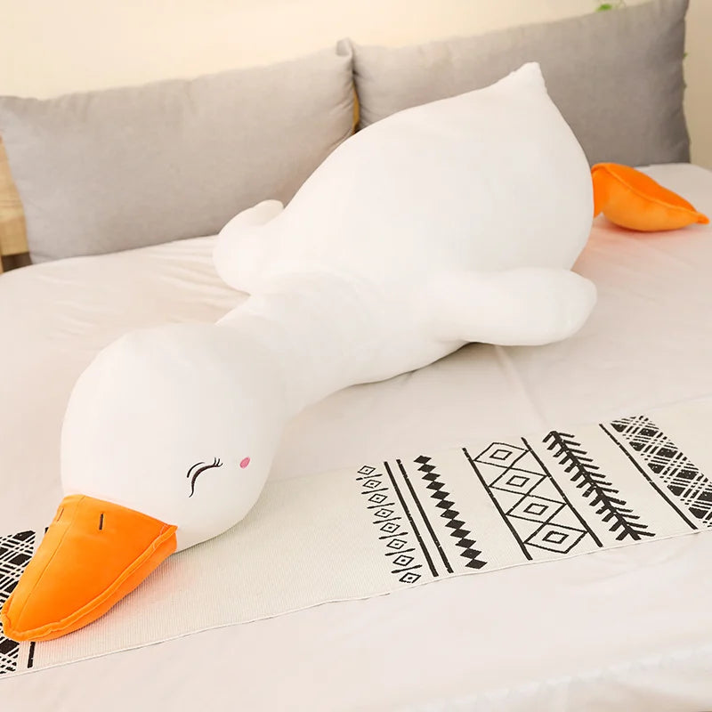 Plush toy goose on a patterned blanket with a neutral background