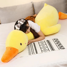 Person lying on a couch with large yellow duck plushie pillow