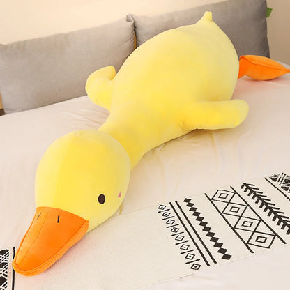 Yellow duck-shaped plush toy on a couch with a patterned blanket