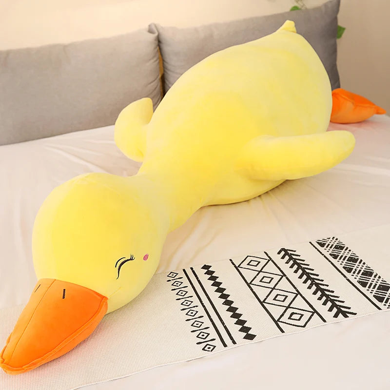 Yellow duck plush toy on a couch with a patterned blanket