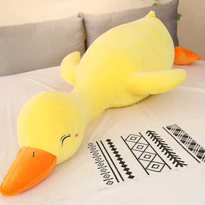 Yellow duck plush toy on a couch with a patterned blanket