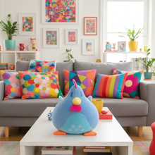 Colorful living room with a gray sofa, decorative pillows, and a plush toy on a coffee table.