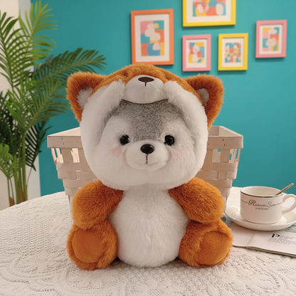 Plush toy resembling a fox sitting on a table with a cup and saucer in the background.