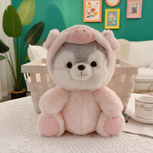 Plush toy with pink pig ears on a table with a green wall and plants in the background