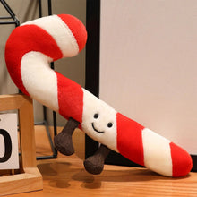 Plush candy cane toy with a smiling face on a wooden surface