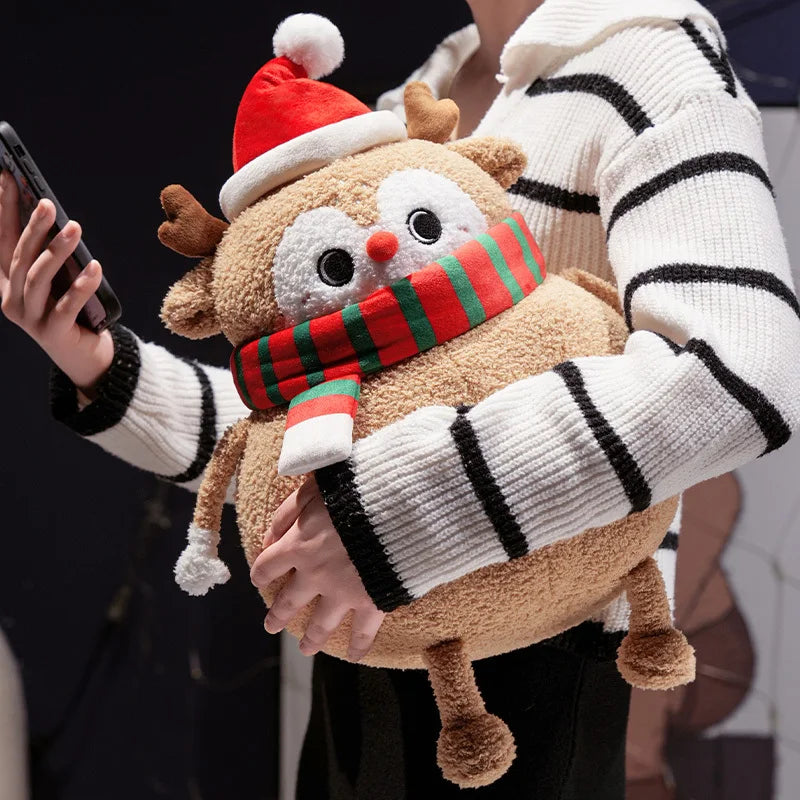 Person holding a plush reindeer toy with a striped sweater and Santa hat.