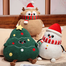 Three Christmas-themed plush toys: a reindeer, a tree, and a snowman, sitting on a wooden surface.